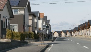  仮設住宅（右）の向かいに新築の住宅が立ち並ぶ（福島県いわき市）　（C）時事