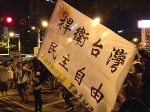  学生たちが立法院を立ち去った日、台北では「勝利」を祝う人々が練り歩いた。「捍衛」は「守れ」の意味（筆者撮影）
