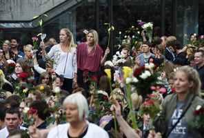 7月25日、オスロで犠牲者追悼のためバラを手に集まる人々 （C）AFP=時事