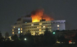 アフガニスタンの首都カブールで、襲撃を受けて炎を上げるホテル （C）AFP=時事