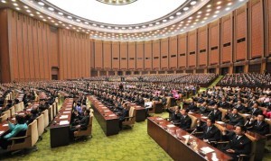  9日、平壌で開かれた最高人民会議第13期第1回会議。代議員証をあげて賛意を表する代議員たち （C）朝鮮通信＝時事