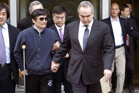 キャンベル国務次官補（右）とロック米駐中国大使（中央）に手を引かれる陳光誠氏（c）AFP＝時事
