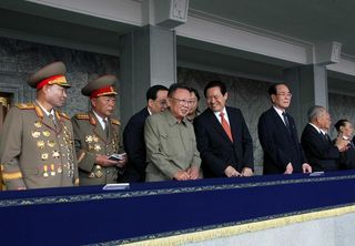 10月10日、閲兵式で談笑する金総書記と周政治局常務委員（C）AFP=時事