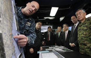 米空母ロナルド・レーガンに乗艦し、救援活動の説明を受ける北沢俊美防衛相（右から３人目）とルース駐日米大使（同２人目） （C）時事