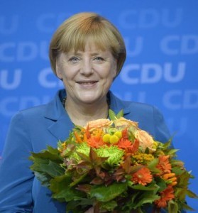  勝利の花束に顔をほころばせるメルケル首相　（C）AFP＝時事